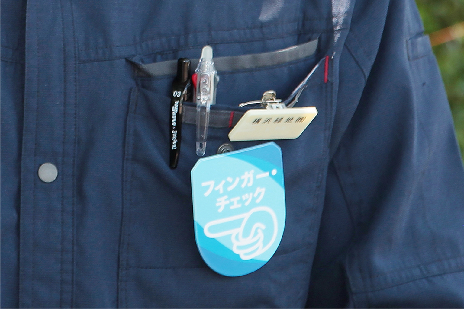 フィンガー・チェックのロゴマークが入ったバッジ